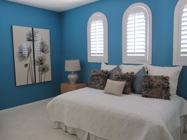 Bedroom with white plantation shutters.